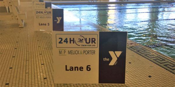 Image of YMCA signage featuring their logo in front of their indoor pool