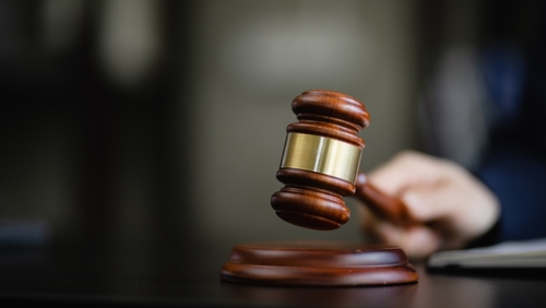 Hand holding a wooden gavel, a wooden legal gavel on an office desk, Judge gavel, Law,